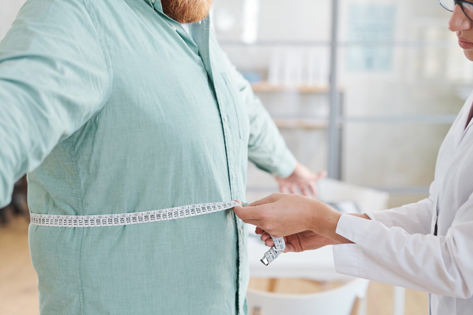 Close-up,Of,Doctor,Measuring,Waist,Of,Overweight,Man,During,His