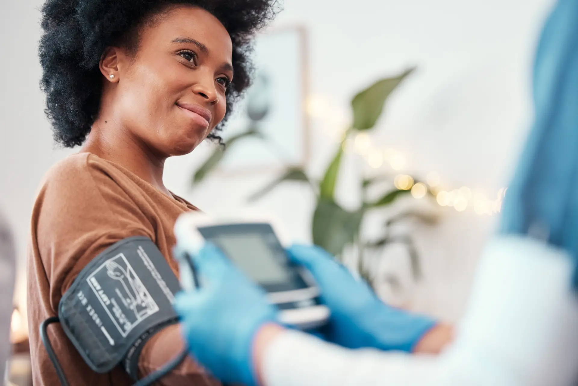 Healthcare professional measuring a woman’s blood pressure with an upper-arm cuff