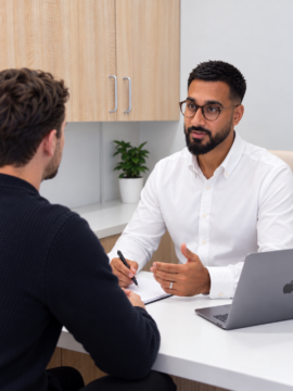 Pharmacist consulting with a male patient in a private pharmacy consultation room about weight loss.